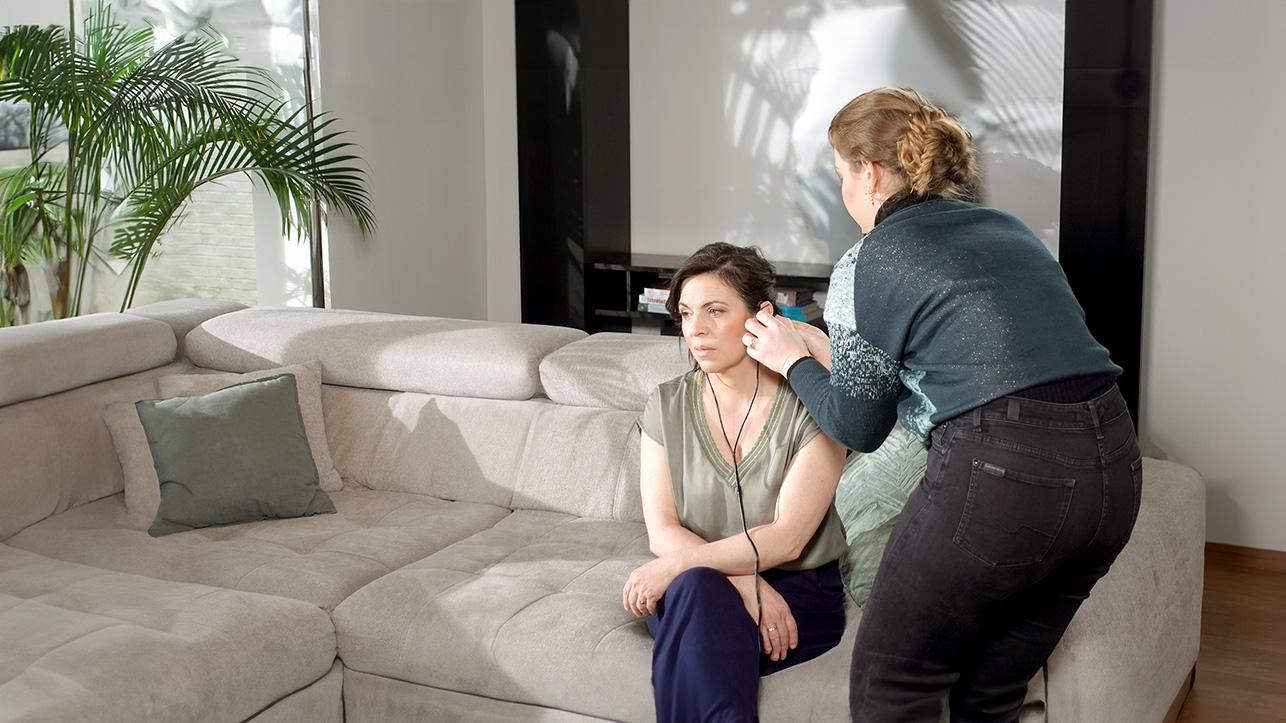 Audioloog meet het gehoor van een vrouw tijden de thuisservice